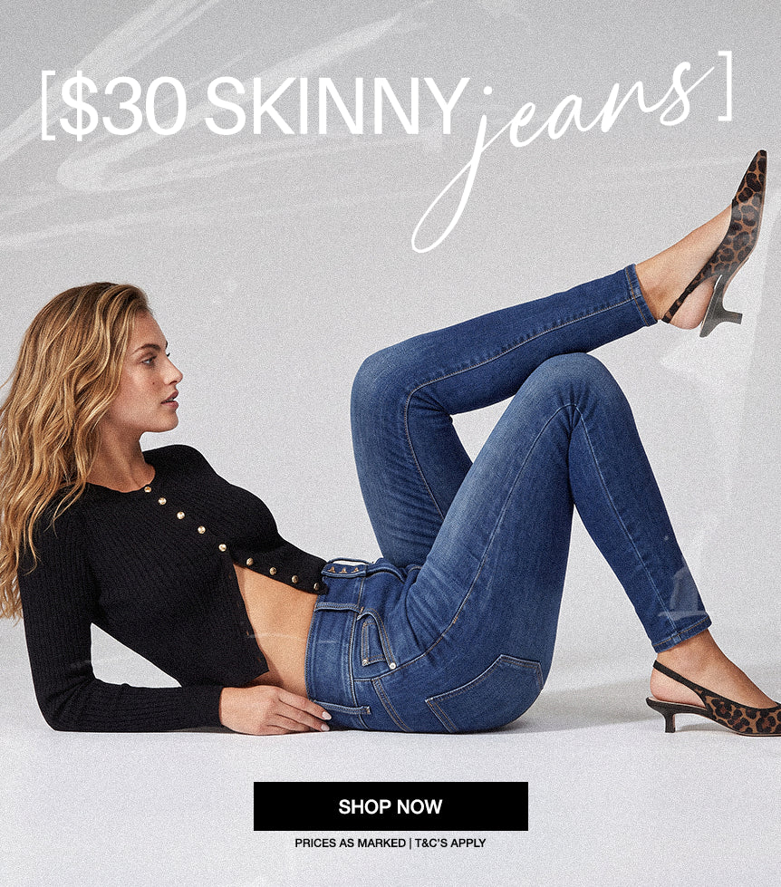 A model laying down wearing a black sweater and dark wash skinny in a white studio background. Text reading [$30 Skinny Jeans], a black CTA "Shop Now" and a tet underneath reading Prices as Marked | T&C's Apply. Mobile Banner