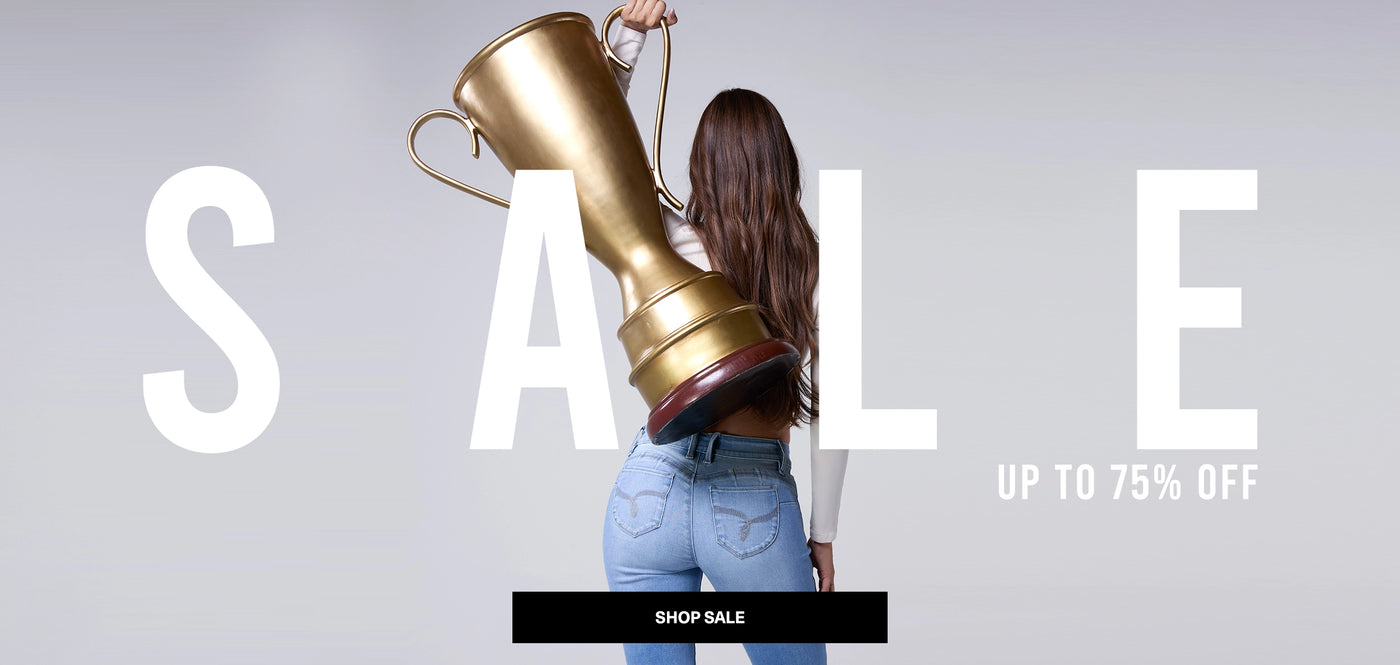 Woman holding a large gold shoe with 'SALE' text and discount offer on a gray background